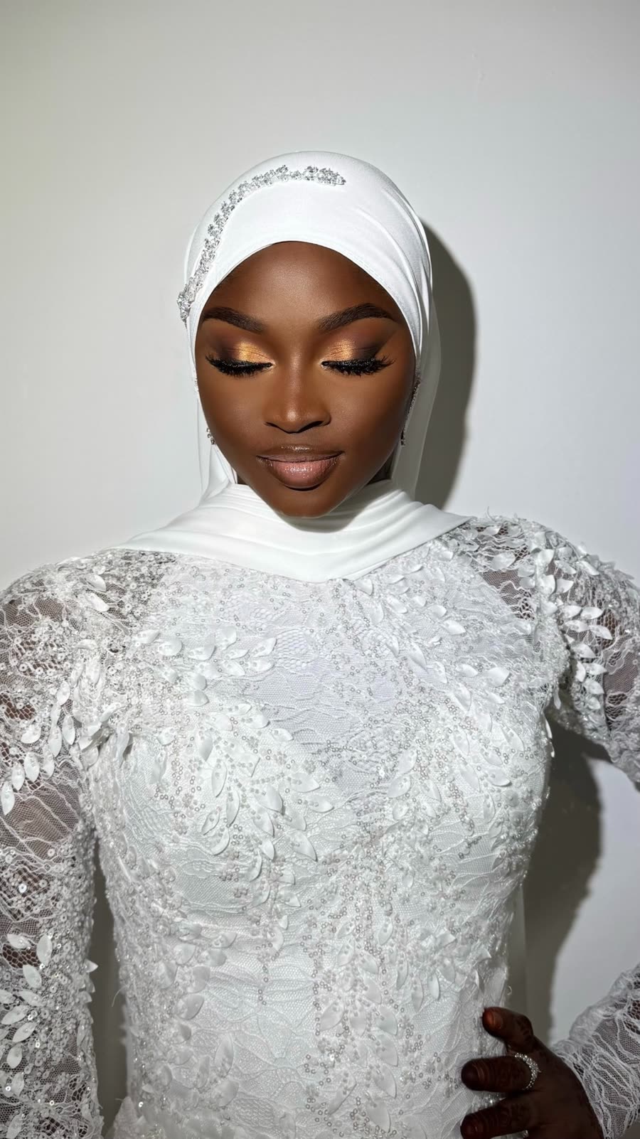 Mariée en hijab satiné avec maquillage doré